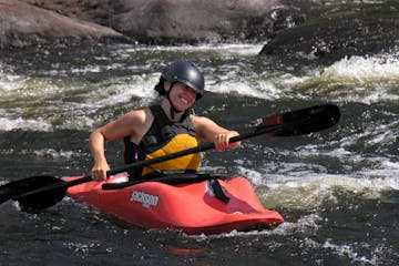 woman in her red kayak paddle down the river