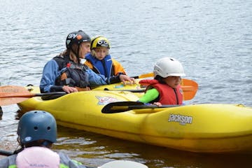 2 kids learning how to kayak