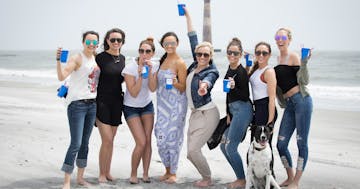 Women holding cups on beach