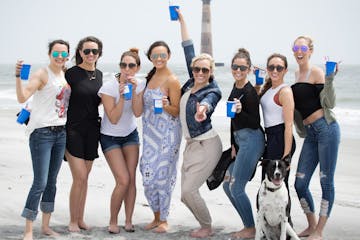 Women holding cups on beach