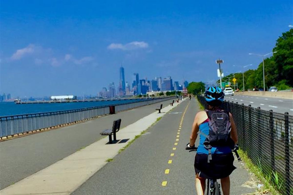 ebike on greenway by ocean with nyc skyline