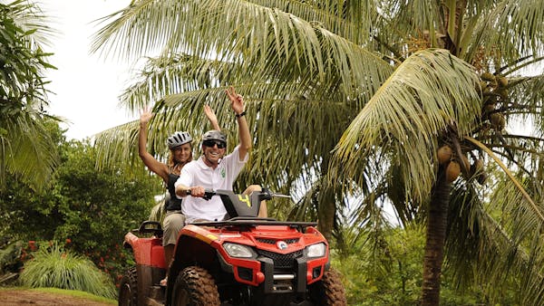 A woman riding with a guide on an ATV
