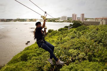 A woman ziplining across to the base