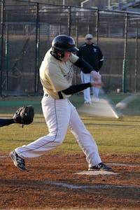 a baseball player swinging a bat at a ball