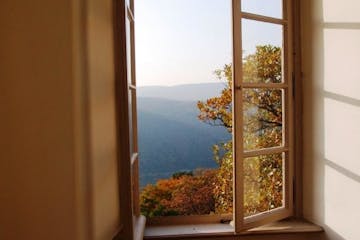 Offenes Fenster mit Ausblick auf Berge