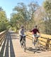Couple holding hands while biking