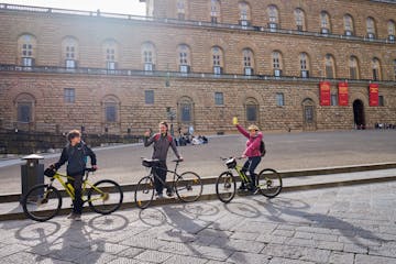 People in bikes in front of stone brick building
