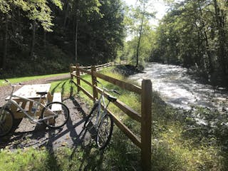 Two bikes resting by a picnic bench along the scenic trail