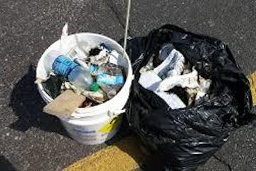 A bucket and bag full of litter collected from the river
