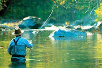A fly fisher throwing his line over the river