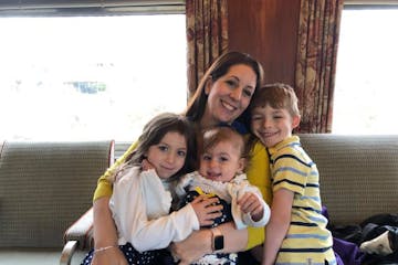 a woman holding children on a train