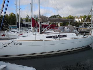 Side view of North Twin sailboat sitting in water