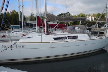 Side view of North Twin sailboat sitting in water