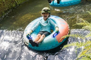 a young boy riding on a raft in a body of water