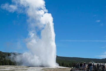 a group of clouds in the sky with Old Faithful in the background