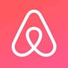 White Airbnb logo, a triangle shape on a pink background