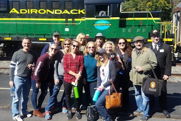 group of people outside green train
