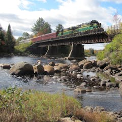 a train crossing a bridge over a body of water