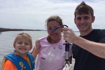 A family of three with a fish