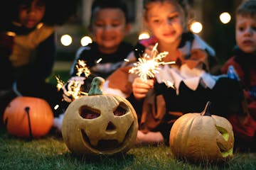 kids with sparklers and jack-o-lanterns