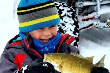 a little boy holding a fish