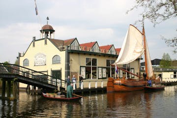 Aman on a small boat next to an old house on a canal in Alkmaar