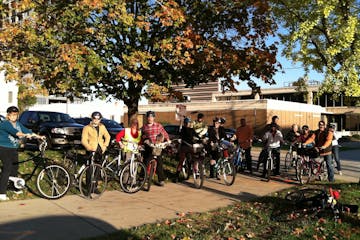 Group of people on bikes with fall foliage behind them on sun on their faces
