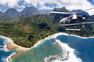 a helicopter flying alongside the coast of Kauai