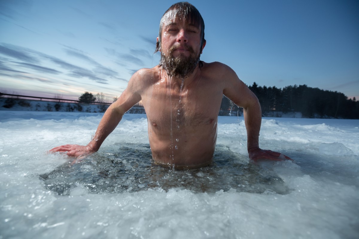 Hombre deportistas se da un baño de hielo en la nieve