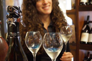 a woman sitting at a table with wine glasses