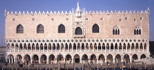 a group of people walking in front of a large building with Doge's Palace in the background