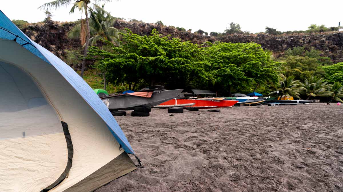 a tent on a black sand beach in hawaii