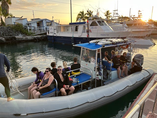 a group of people in a boat docked next to a body of water