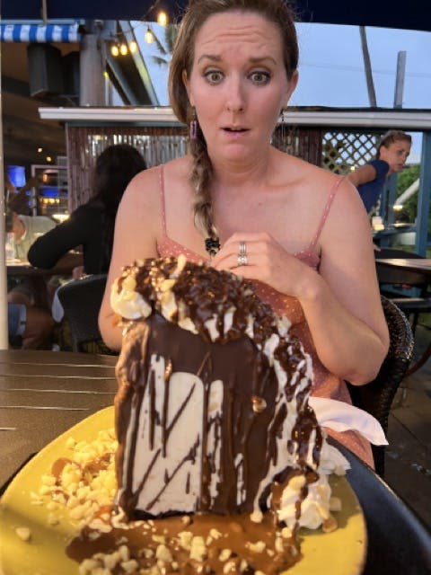 a person sitting at a table with a cake on a plate