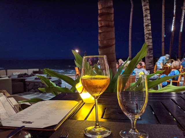 a person sitting at a table with wine glasses