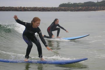 2 young girls doing surfing lessons