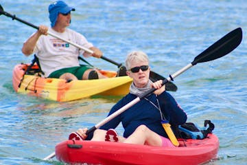 a group of people rowing a kayak in the water