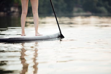 clouse-up of a woman legs on paddleboard in water