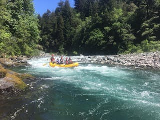 Group of white water rafters navigating down rapids