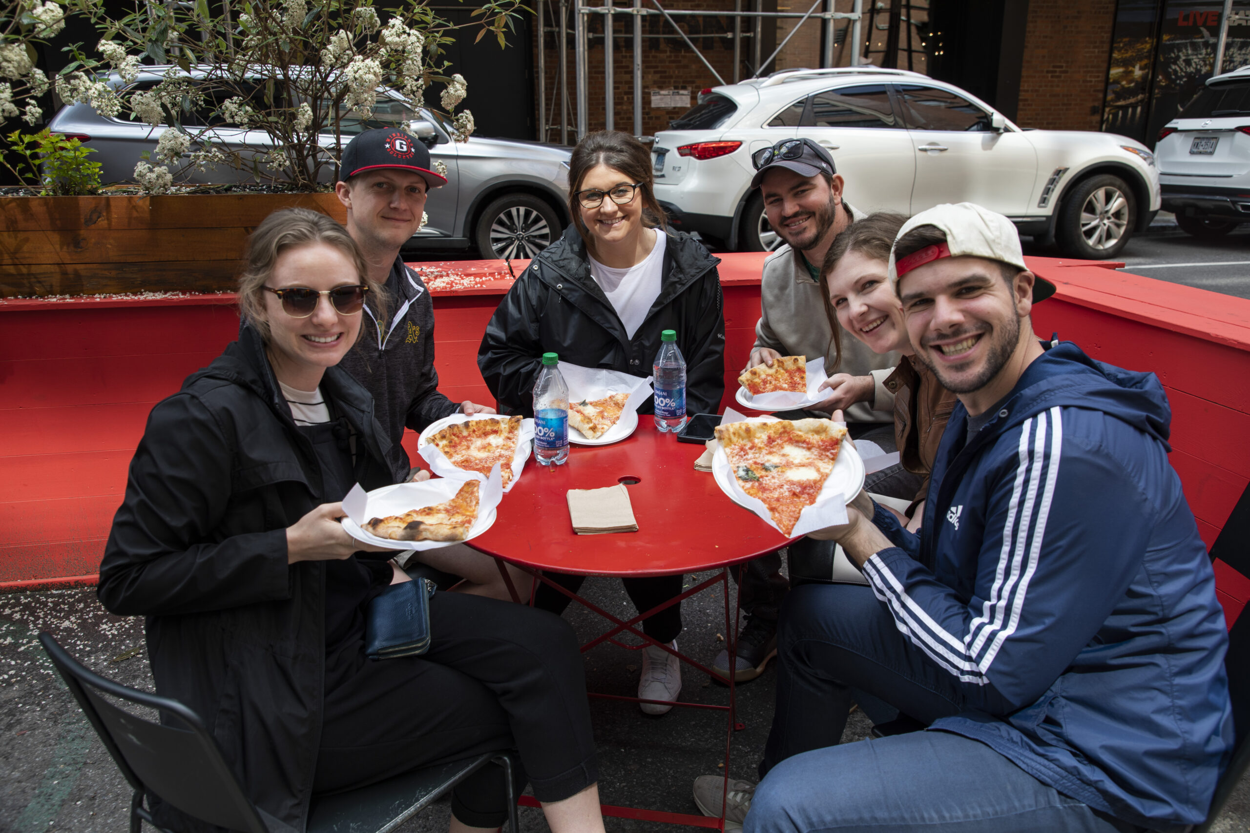 a group of people sitting at a table eating pizza