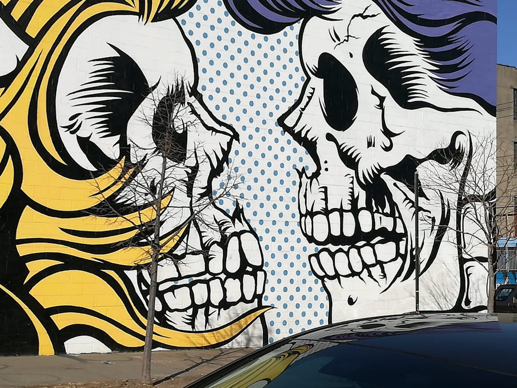 large scale street artwork of two skeletons