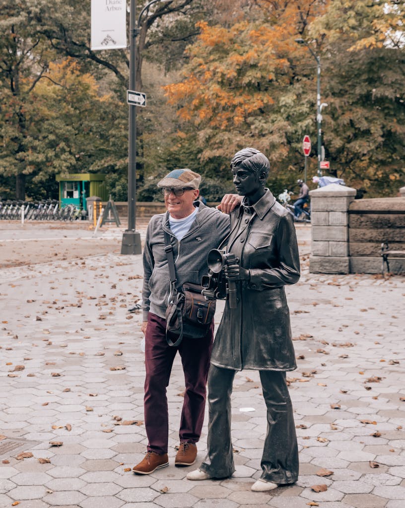 a man standing next to the diane Arbus statue