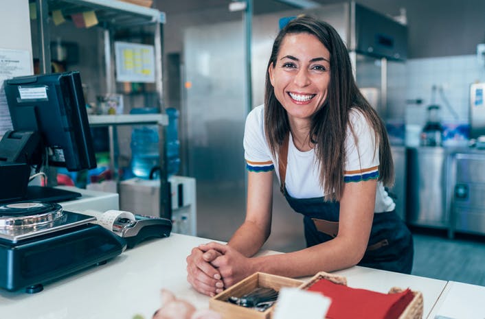 a woman smiling near a cash register