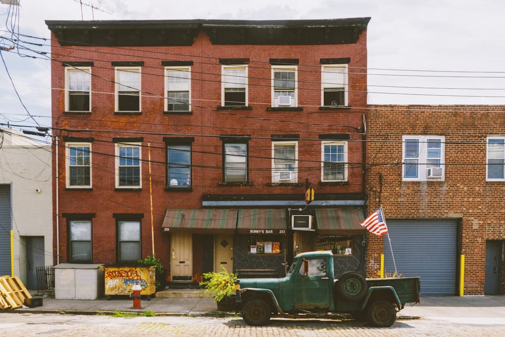 a vintage truck in front of an old brick building with a bar