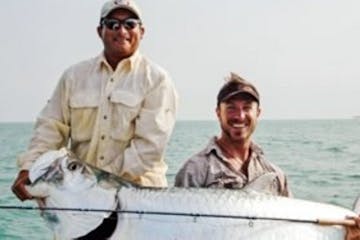 men holding large fish they caught