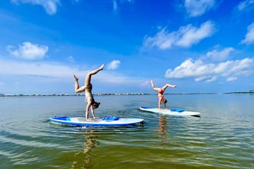 2 girls doing paddle board yoga