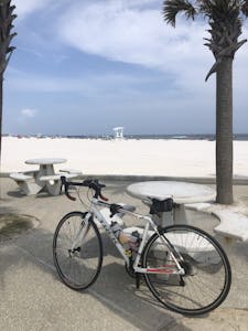 a bicycle is parked next to a picnic table near the beach