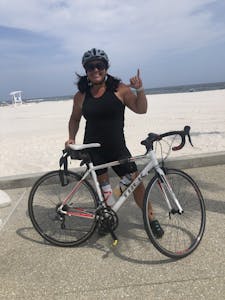 a girl standing behind a bike in gulf shores Alabama 