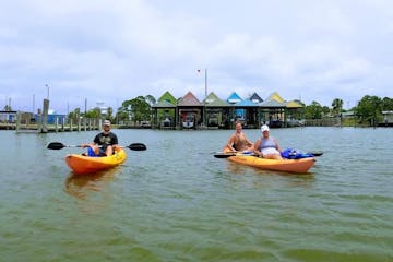 a group of people kayaking in front of colorful houses