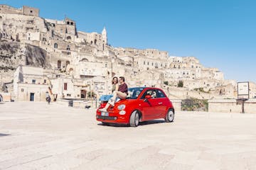 Couple sitting on red fiat 500